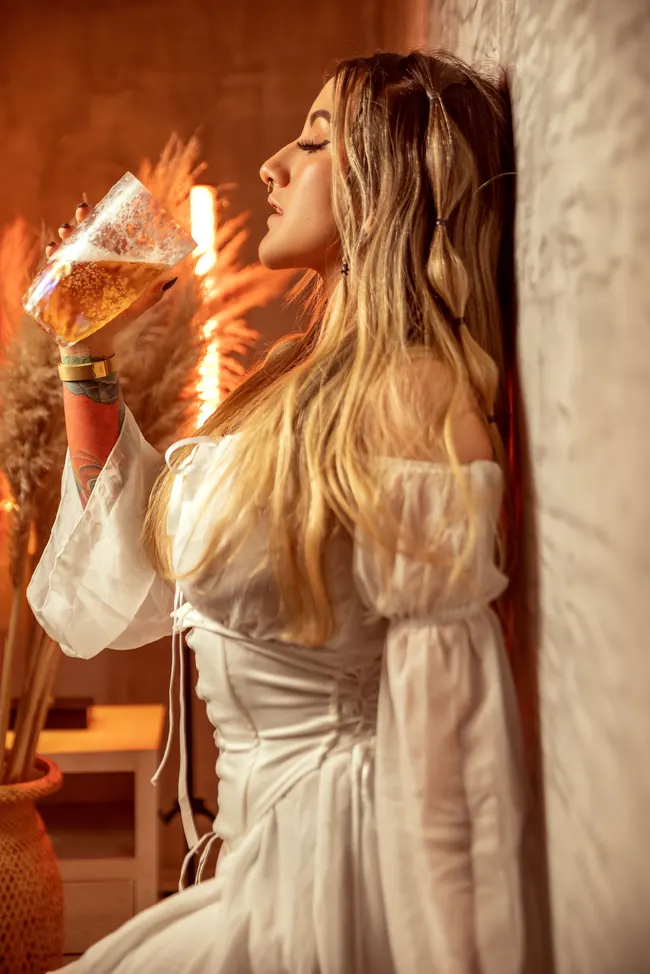 Modelo con vestido blanco y copa en la mano